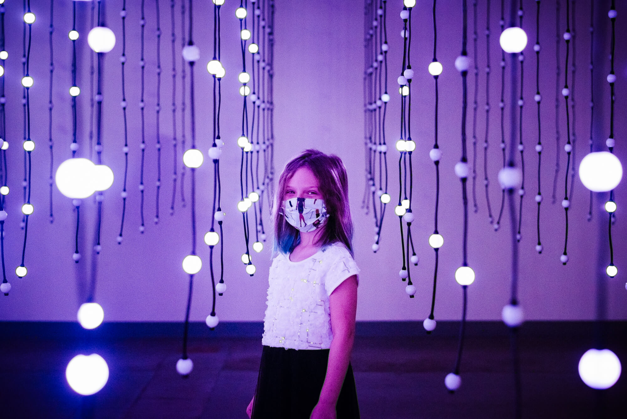 girl standing in blinking art installation at wonderspaces in austin texas