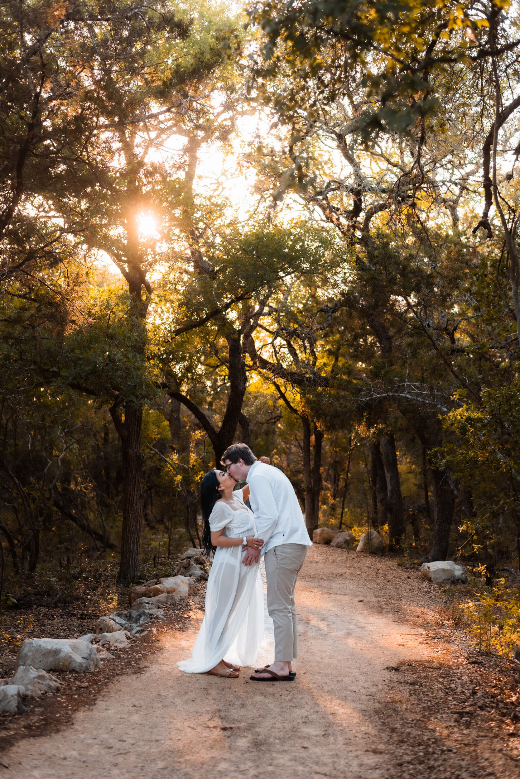 couple kissing for maternity photoshoot