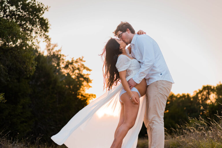 pregnany woman and husband kissing during maternity motherhood portrait session