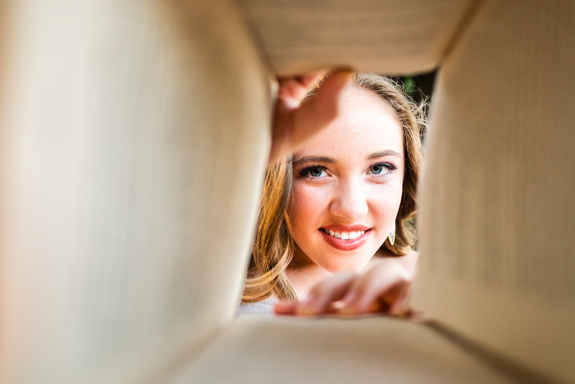 girl looking through book for senior photo