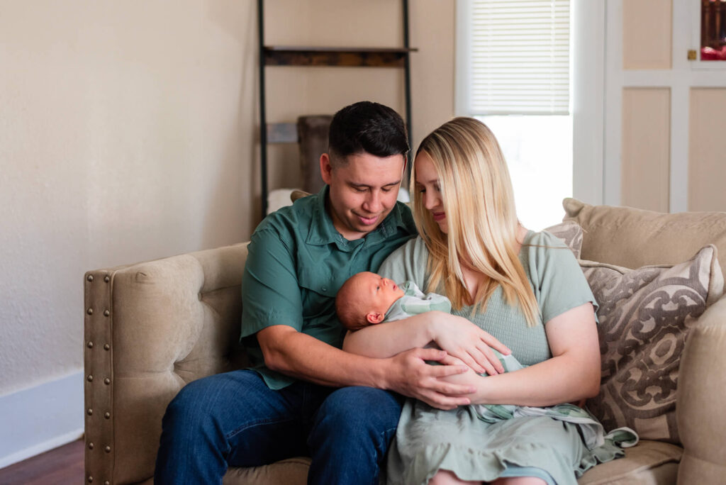 in home newborn photography session of husband and wife holding their newborn baby boy