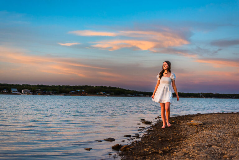 senior girl walking along the edge of the water during photoshoot