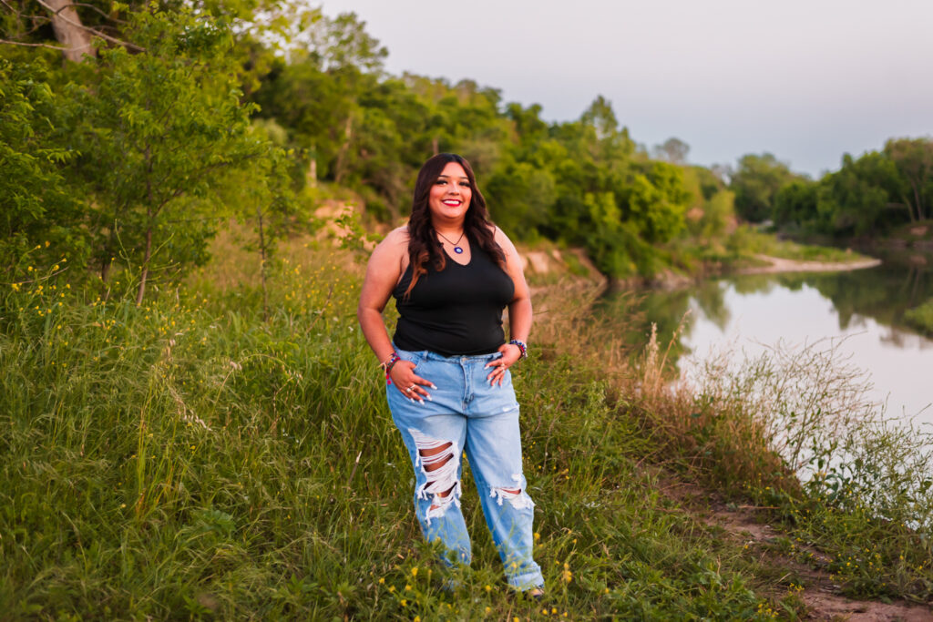 del valle high school senior girl at the bank of the colorado river posing for her senior photos