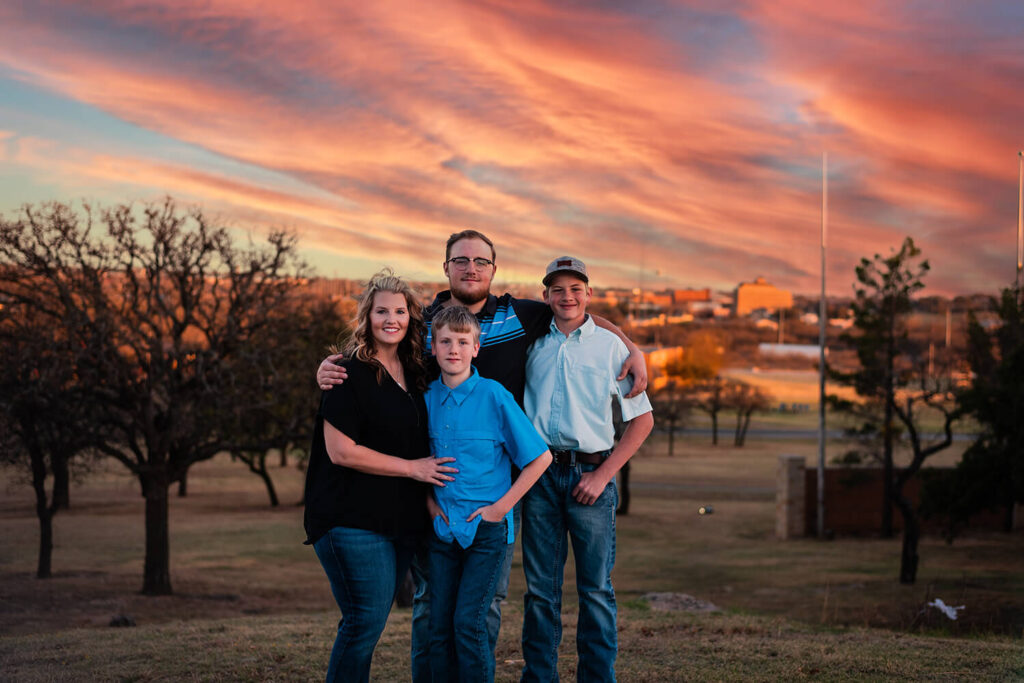 family posing at the top of cisco college hill during sunset