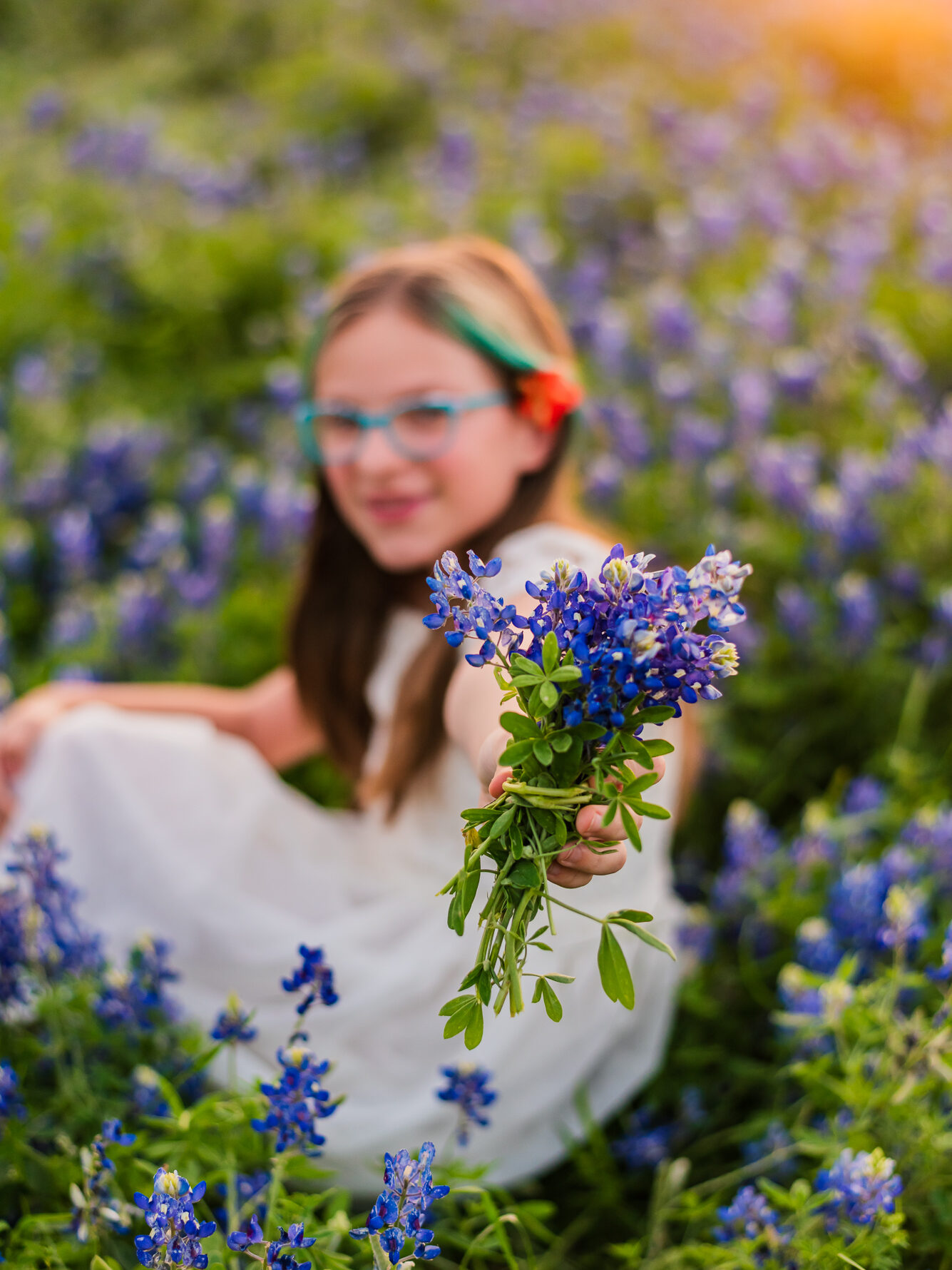 a girl holding bluebonnets in a field in austin texas