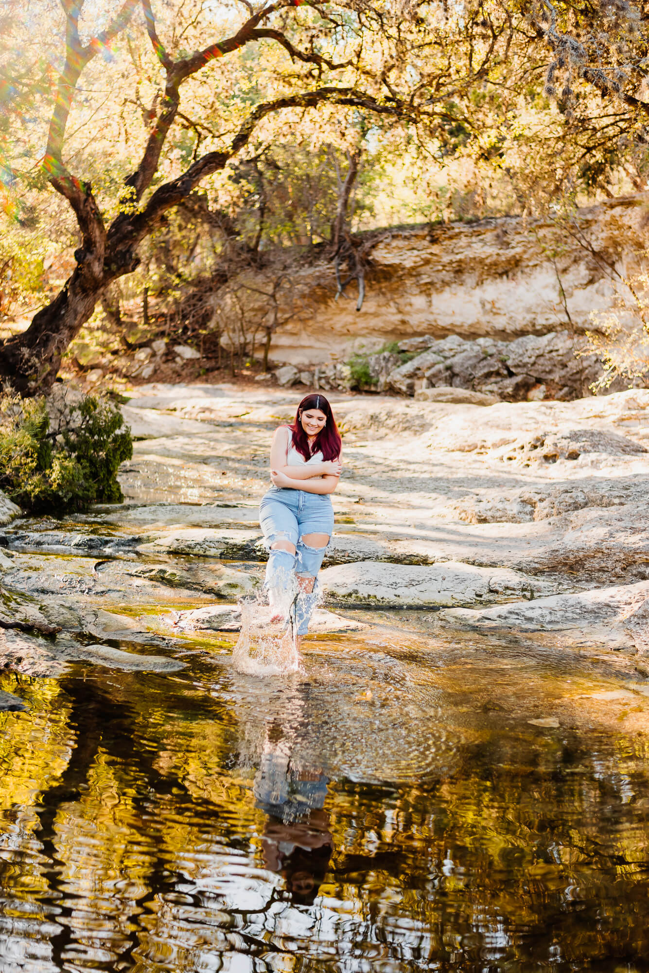 girl kicking water at blunn creek greenbelt in austin texas