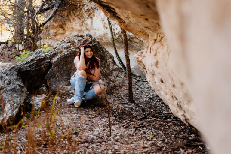 girl sitting near large rocks at blunn creek in austin texas