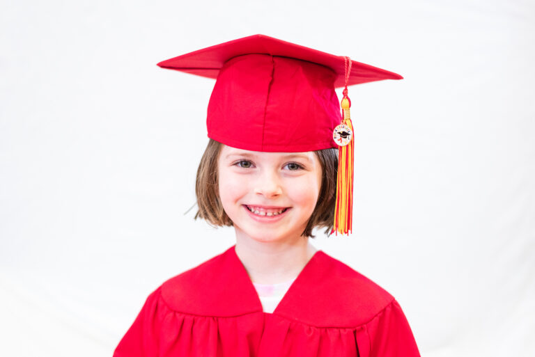 kindergarten girl wearing graduation cap and gown