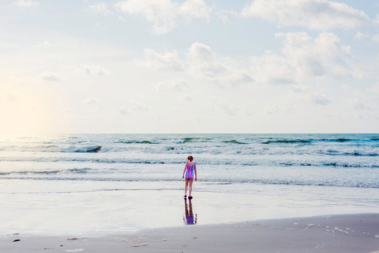 girl standing at the edge of the ocean in texas