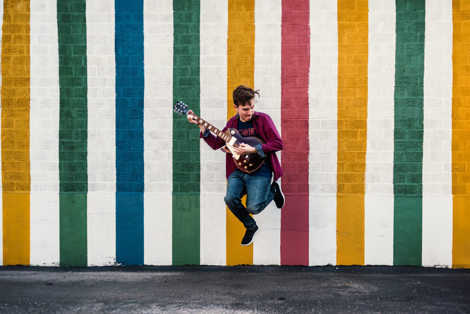 senior boy jumping with guitar