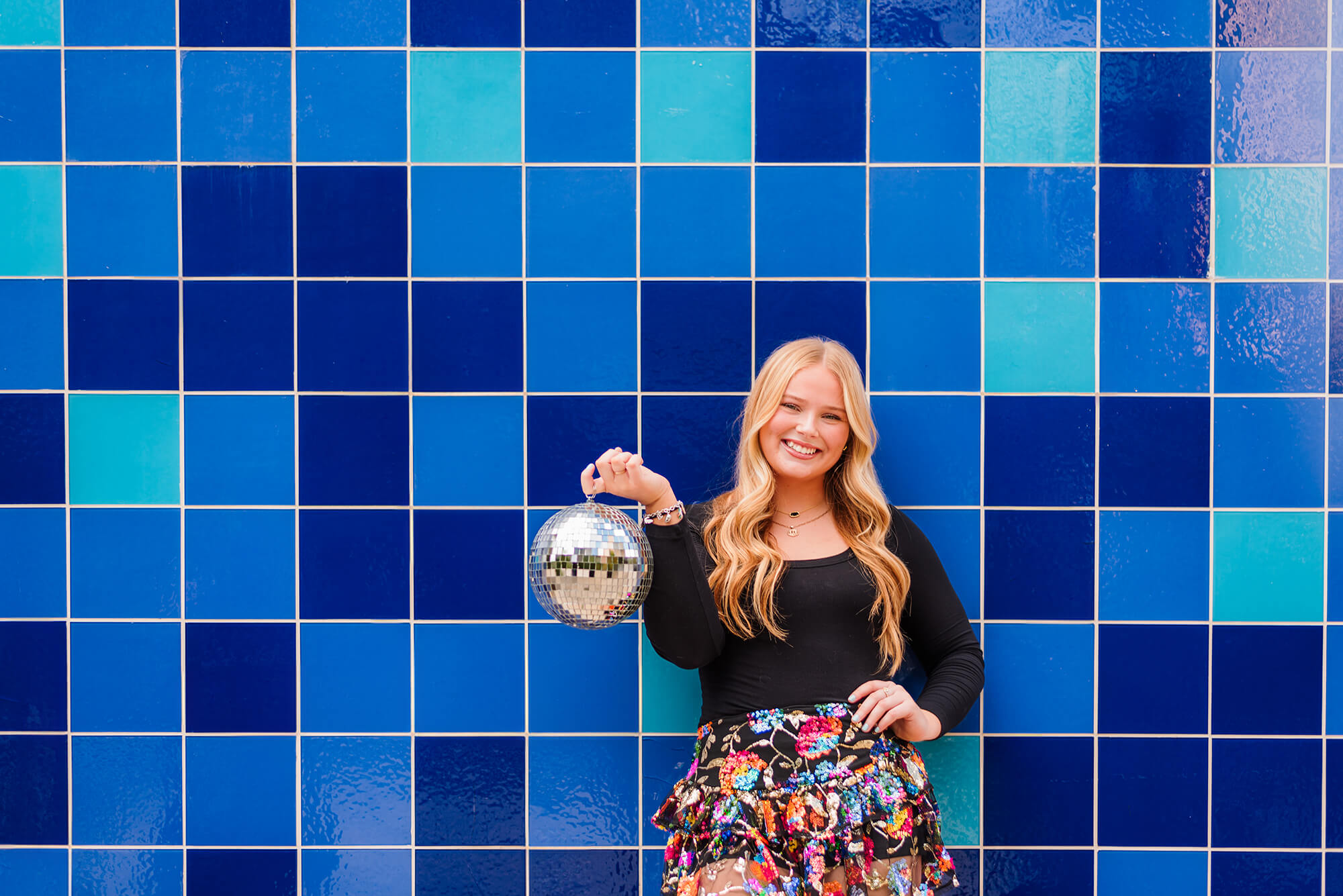 girl holding a disco ball for her senior photoshoot