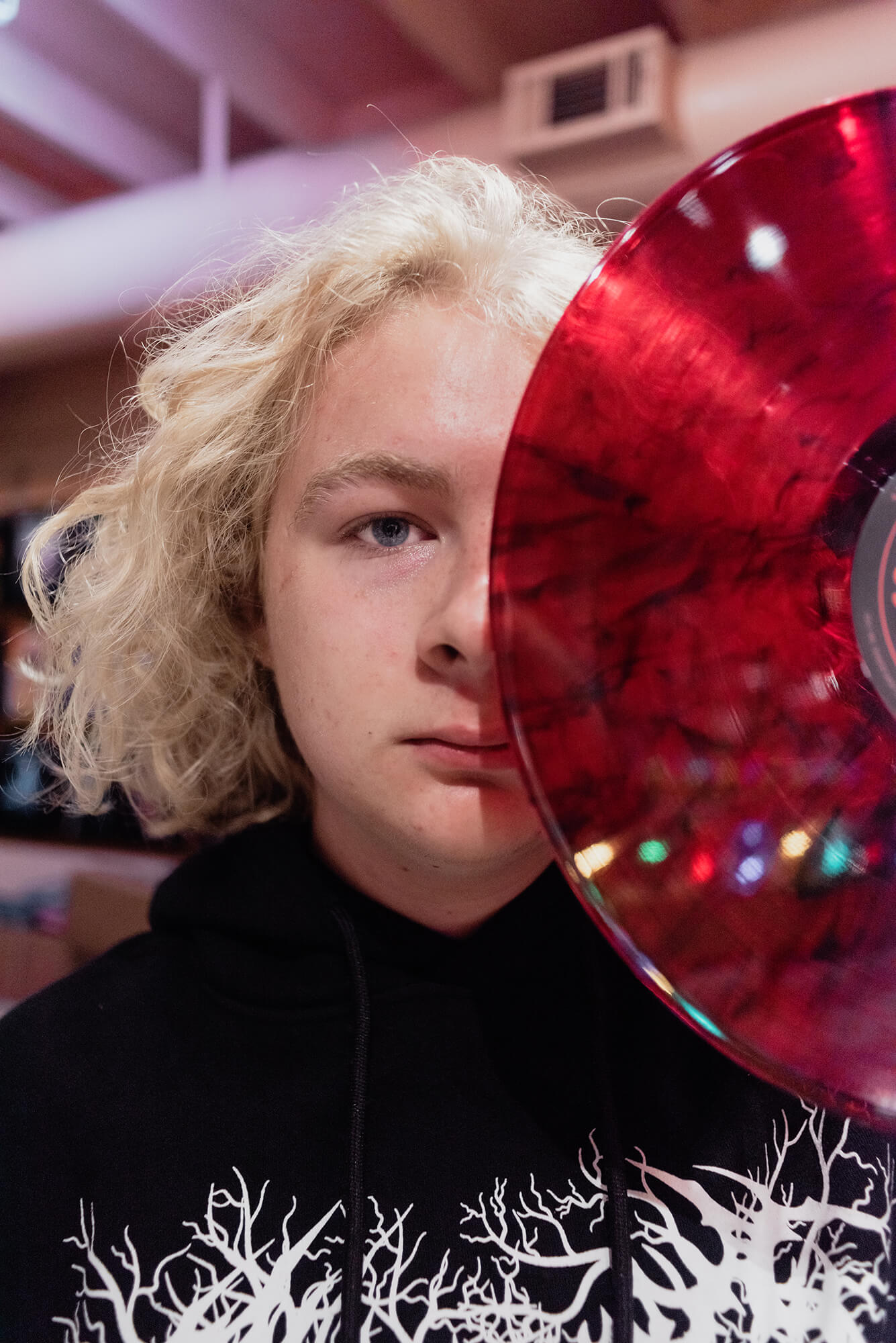 senior holding a record up to his face for a closeup shot for his senior photos