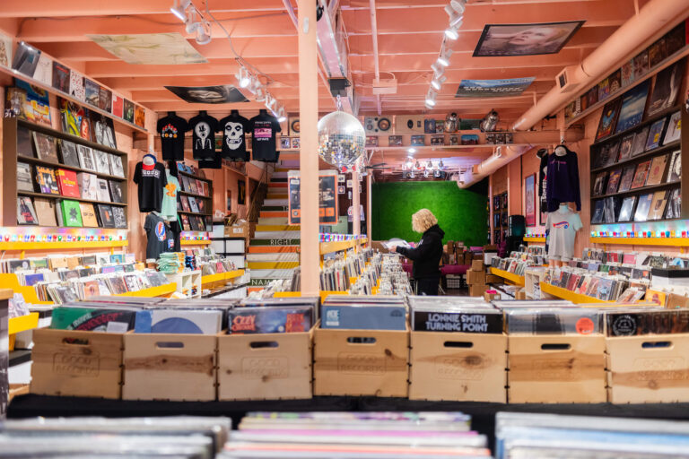 boy browsing through records at record shop for his senior photoshoot