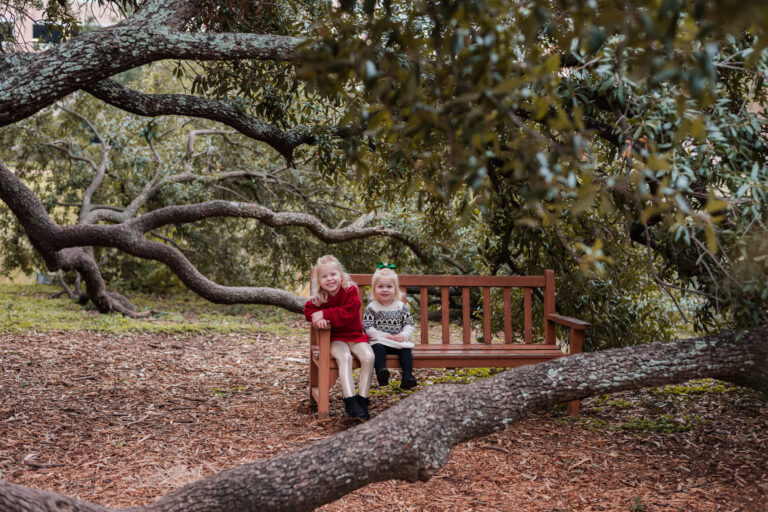 two girls smiling during fall mini sessions at the tree of the year in austin texas from 2008