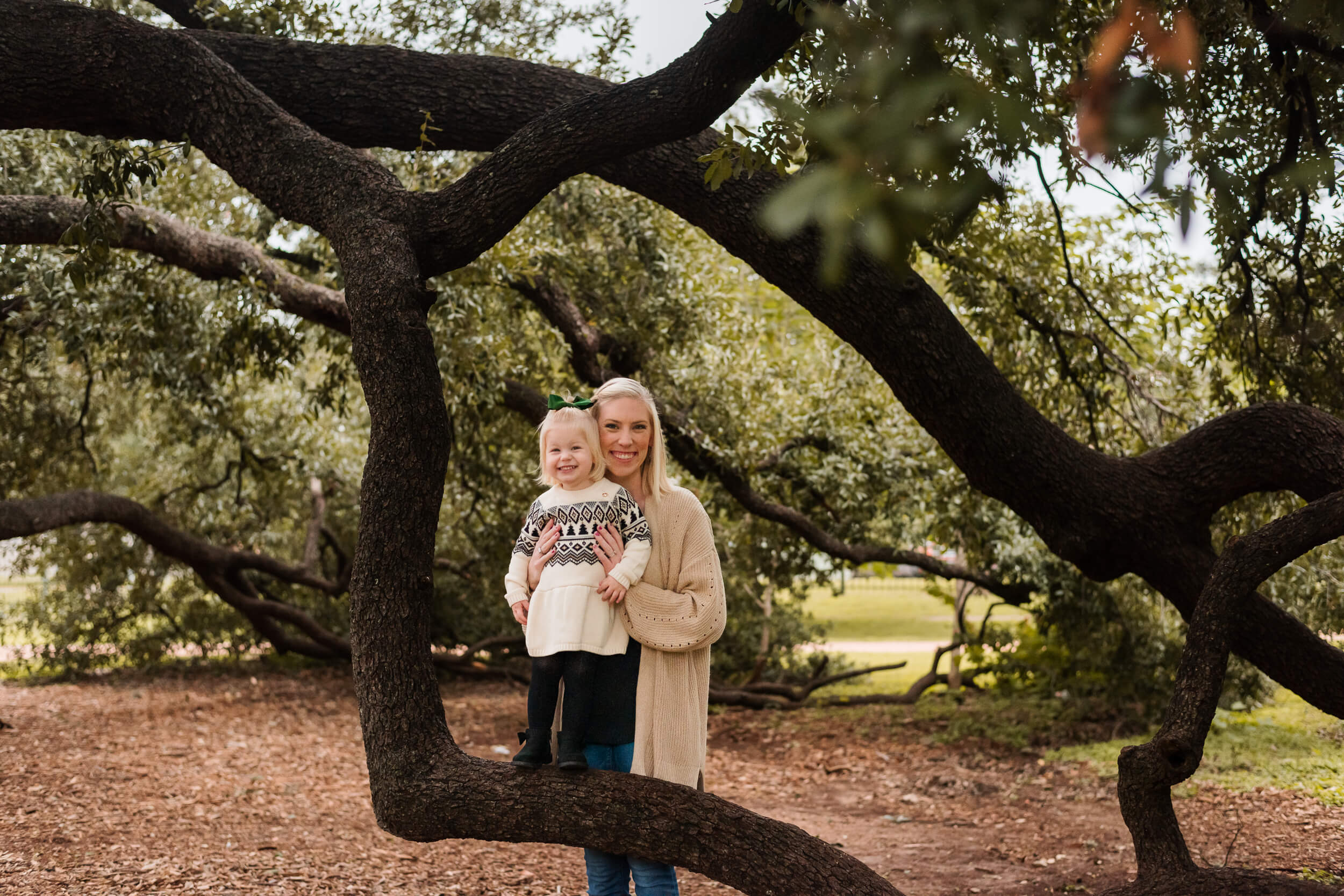 mom and daughter posing at tree of the year in austin texas