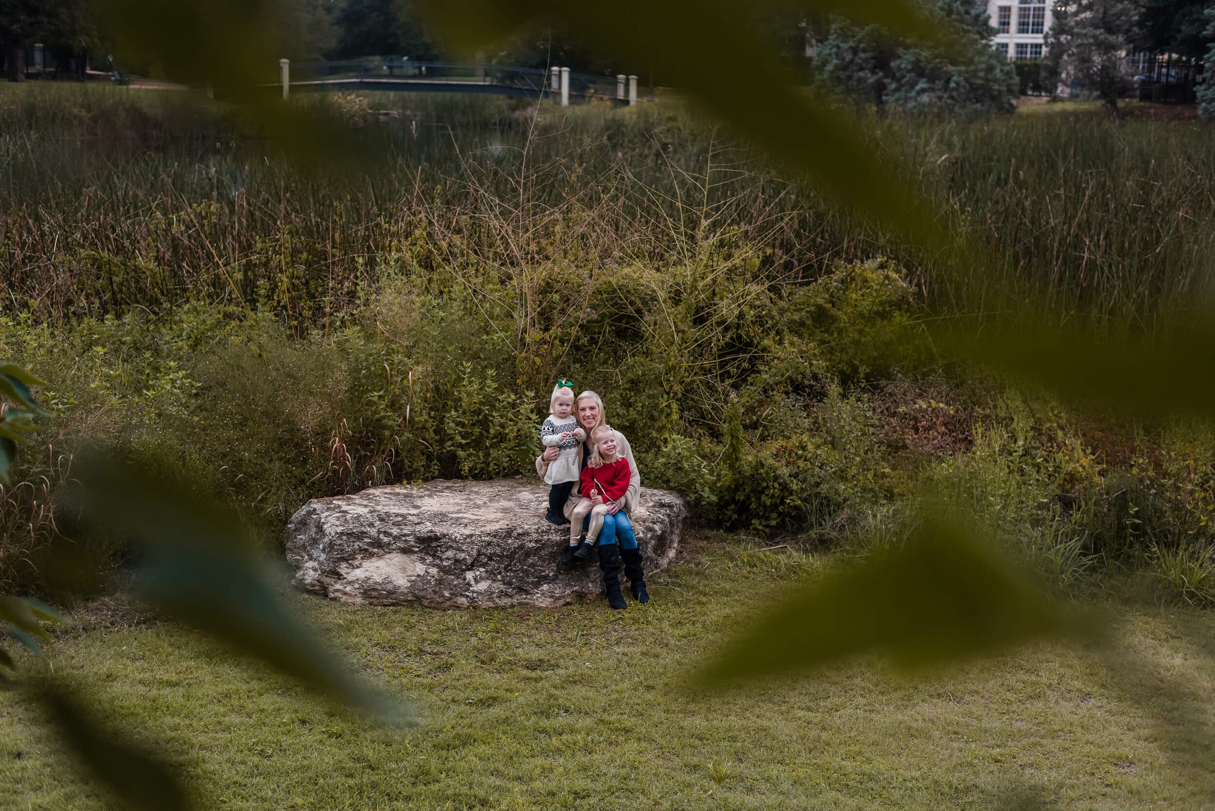 family smiling on giant rock at central park behind central market in austin texas