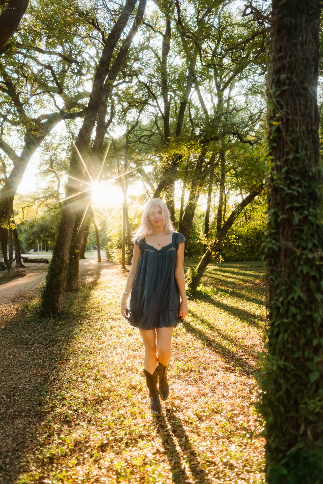 girl walking towards camera with star sun flare for her senior photos