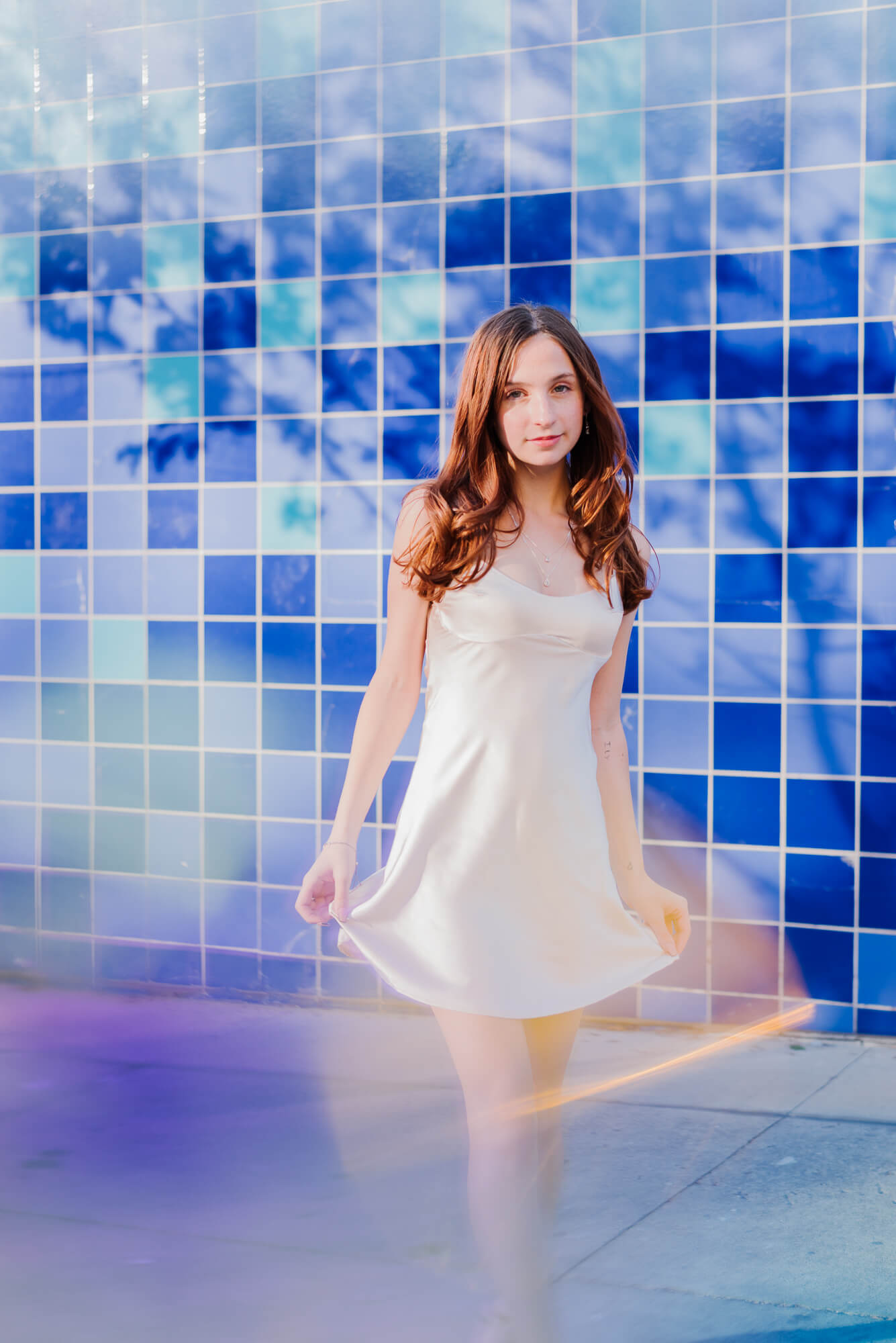 2025 senior at austin high school posing for senior photoshoot at the blue tile wall in austin texas