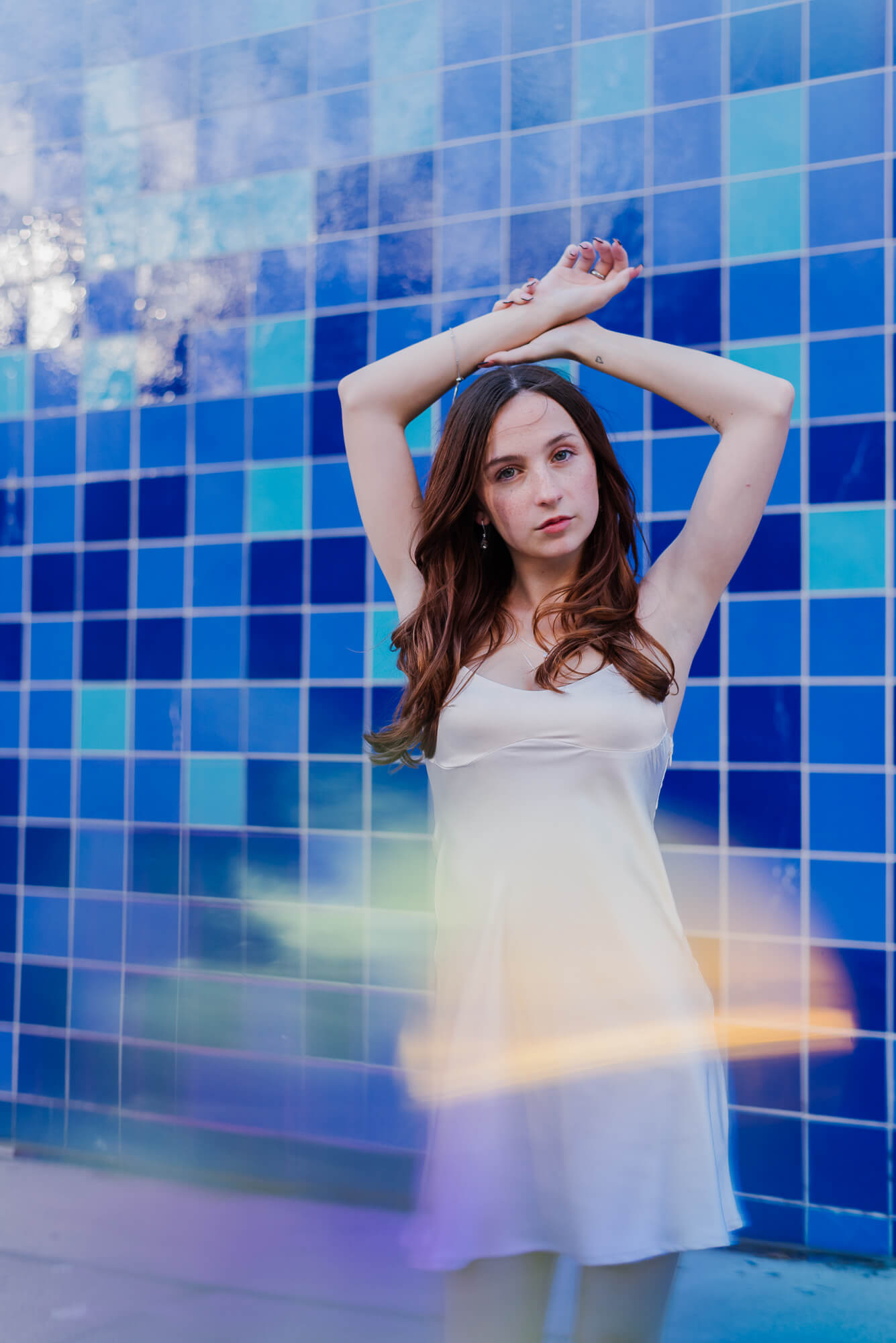 2025 senior at austin high school posing for senior photoshoot at the blue tile wall in austin texas