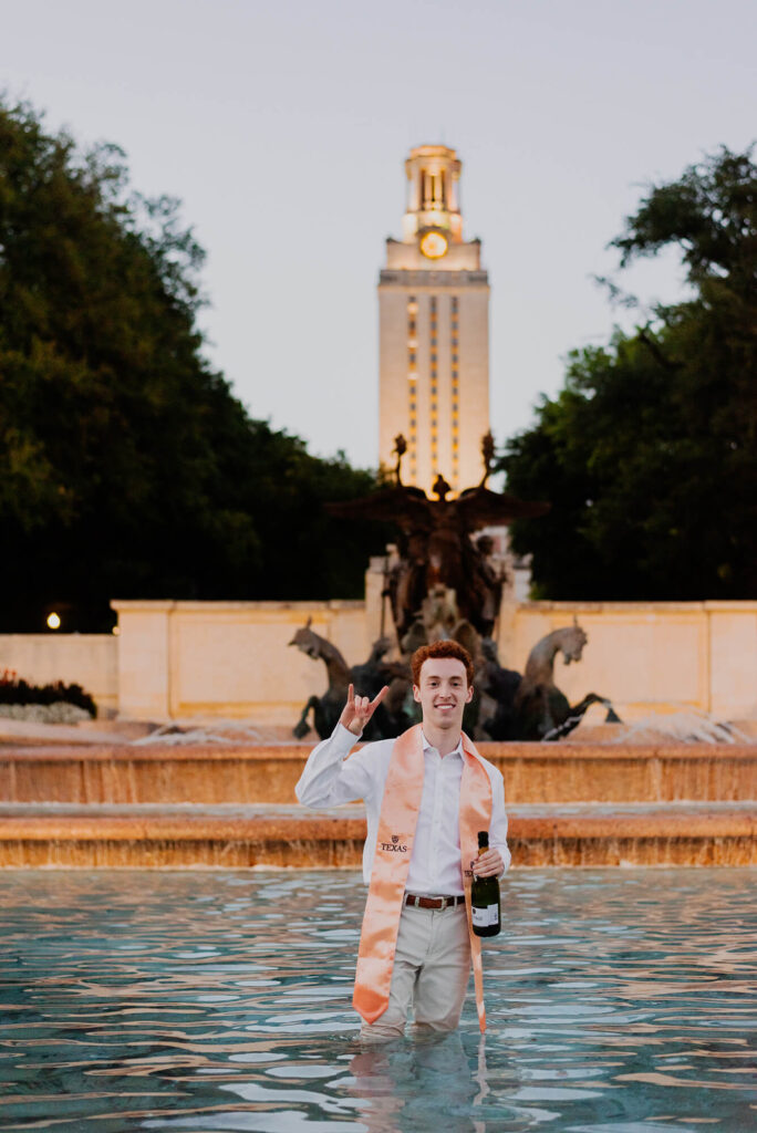 ut austin grad posing in little field fountain