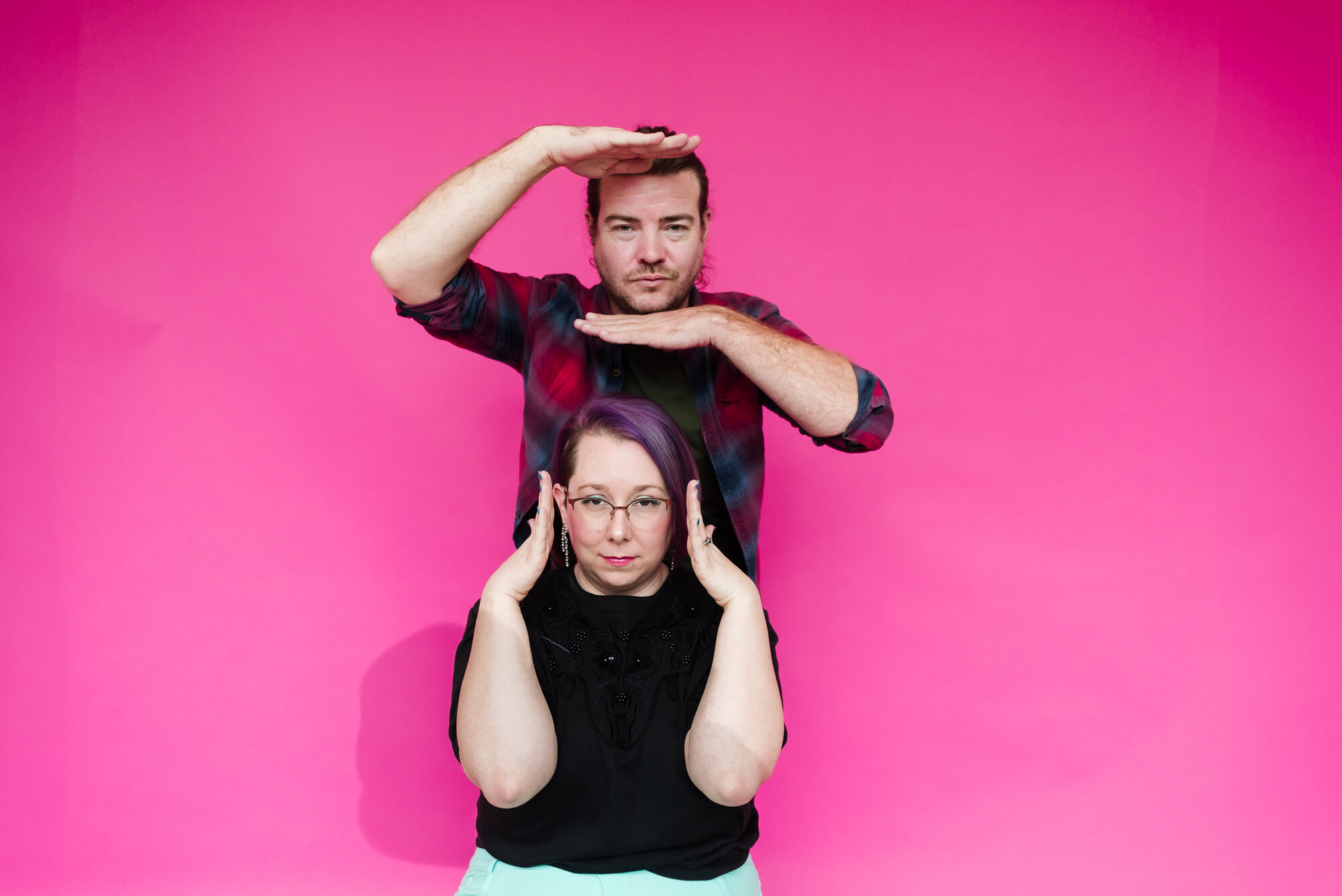 two friends posing with vogue hands for a glamour photoshoot in a studio in austin texas