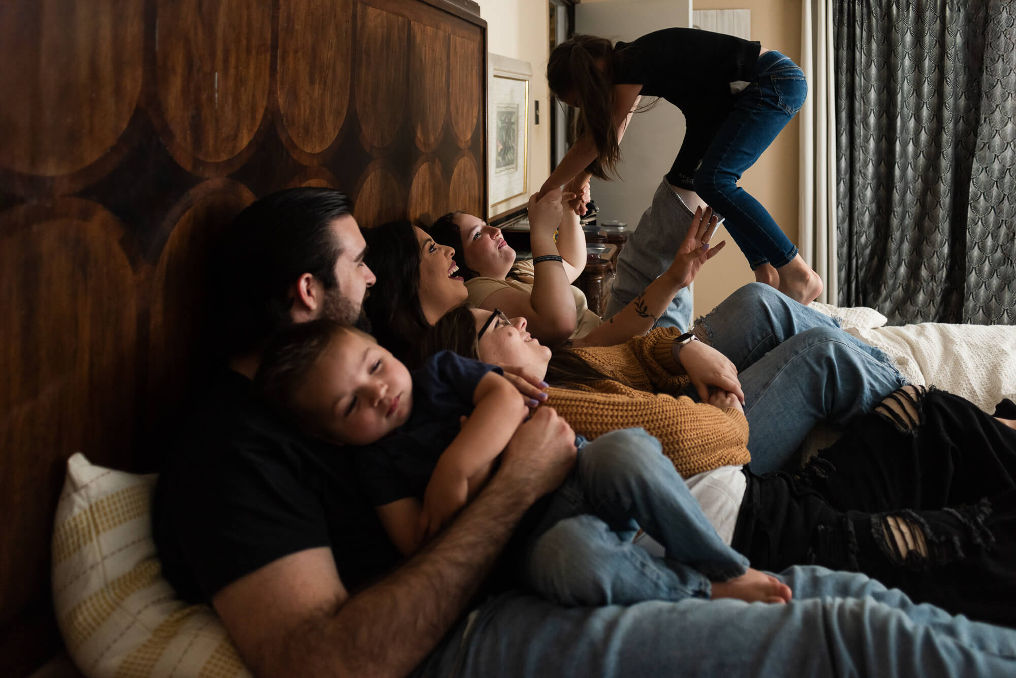 family laying on bed playing during indoor family session