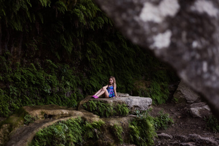girl sitting on rock at bull creek district park creek