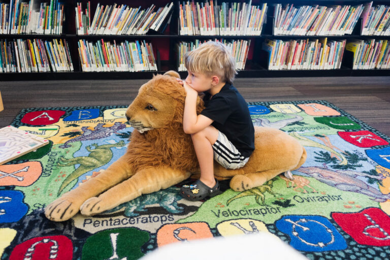 boy sitting in children's area at windsor park library in austin texas