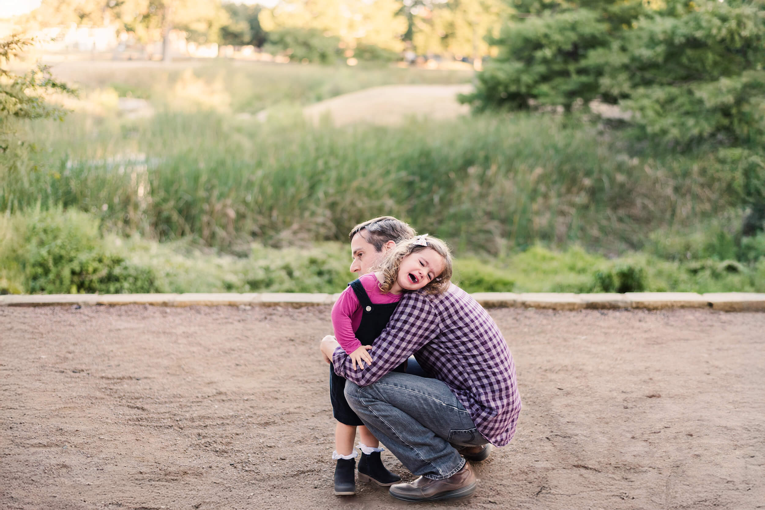 little girl crying in her dad's arms