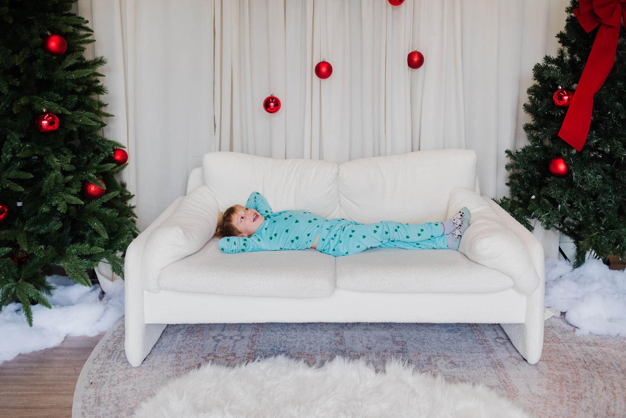 christmas pajama mini session in austin with little boy laying on a couch