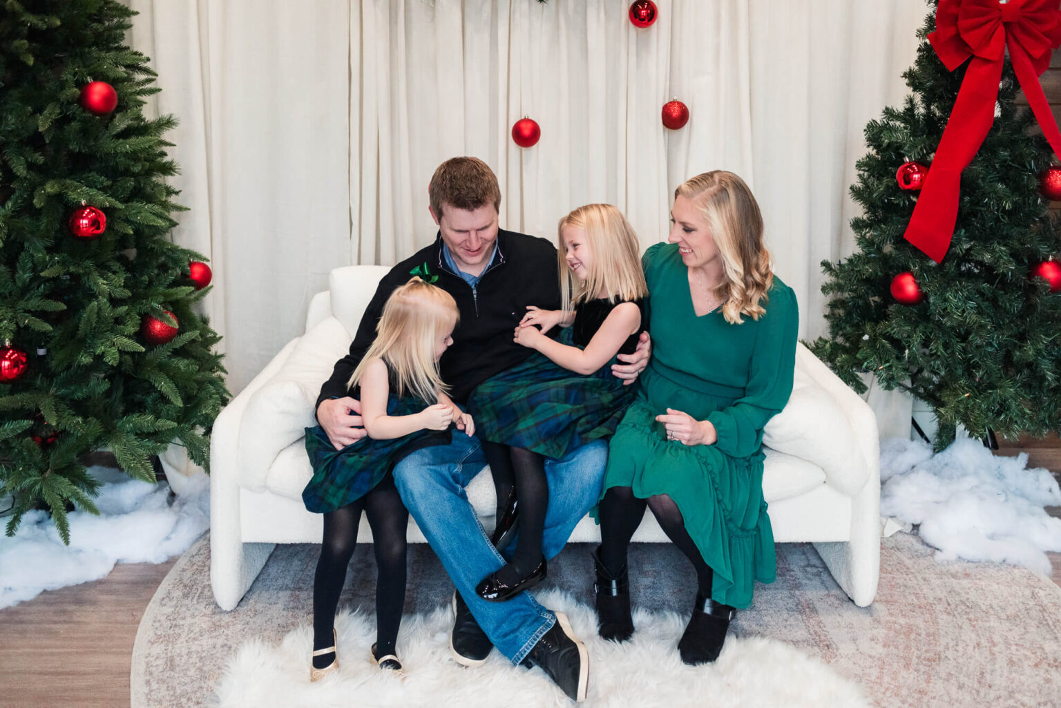 family sitting in studio decorated for a christmas photoshoot in austin texas