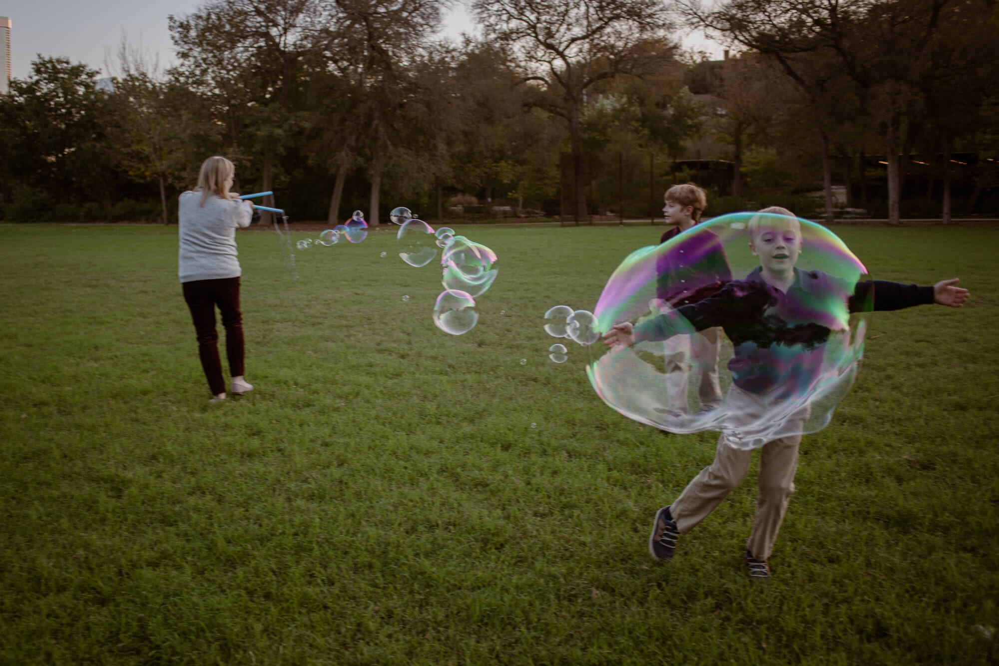 family playing with bubbles outside