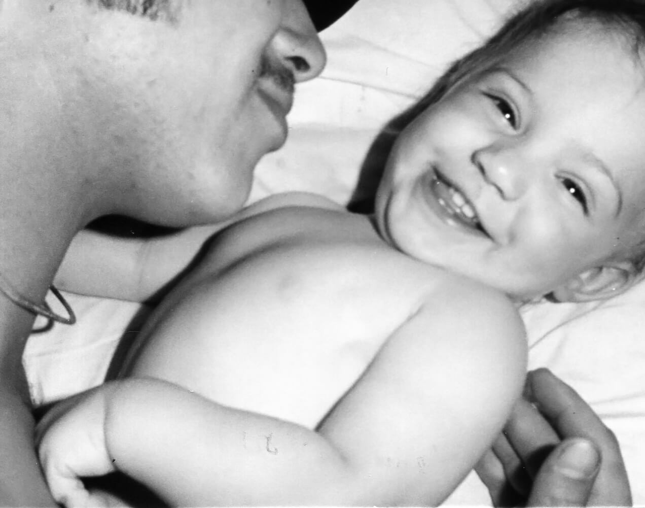 a dad playing with his baby daughter