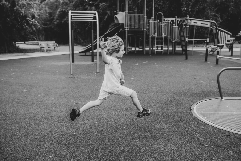 little boy taking huge leaps while running on playground
