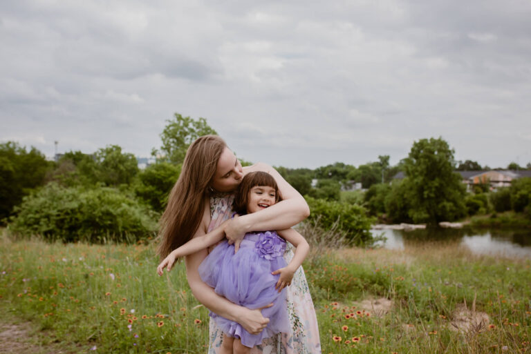 mom holding and kissing her daughter