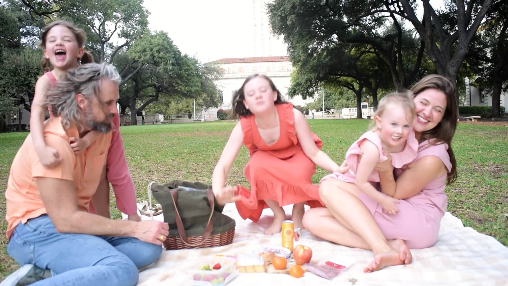 family film image still from green family home movie shot at ut austin with all kids playing with mom and dad during picnic
