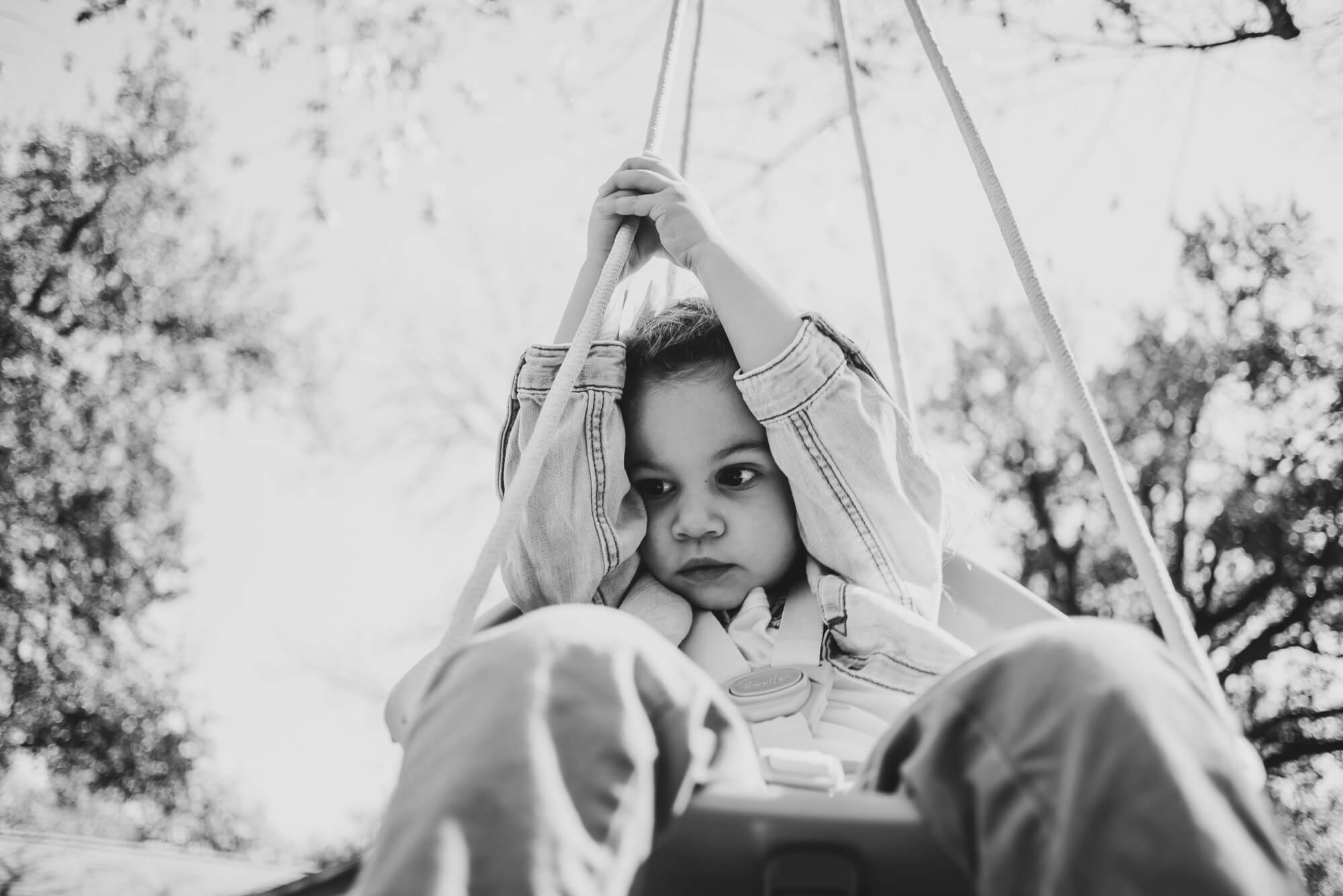Toddler on the swing at home during an at-home family photoshoot in Austin