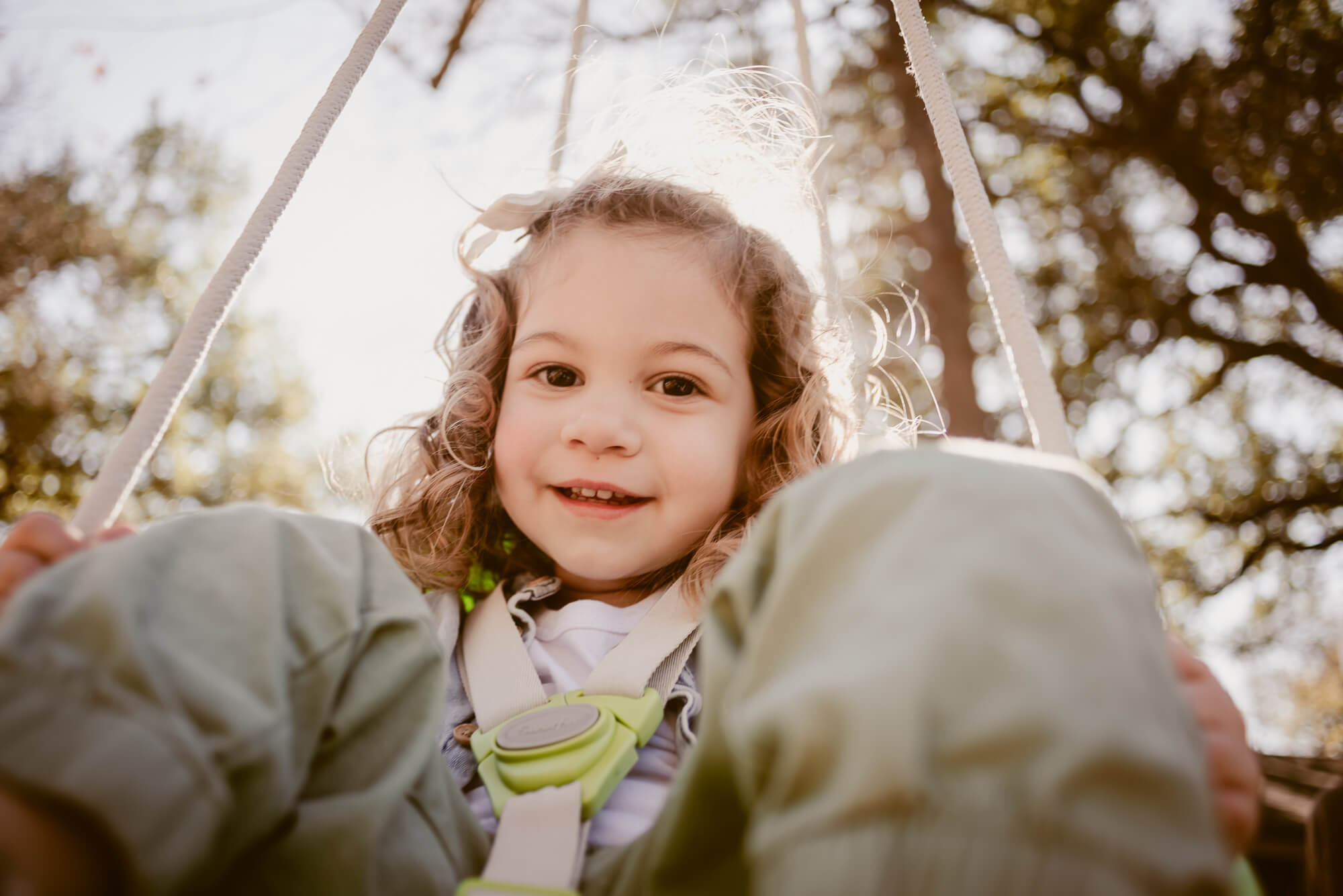 Toddler smiling on the swing at home during an at-home family photoshoot in Austin