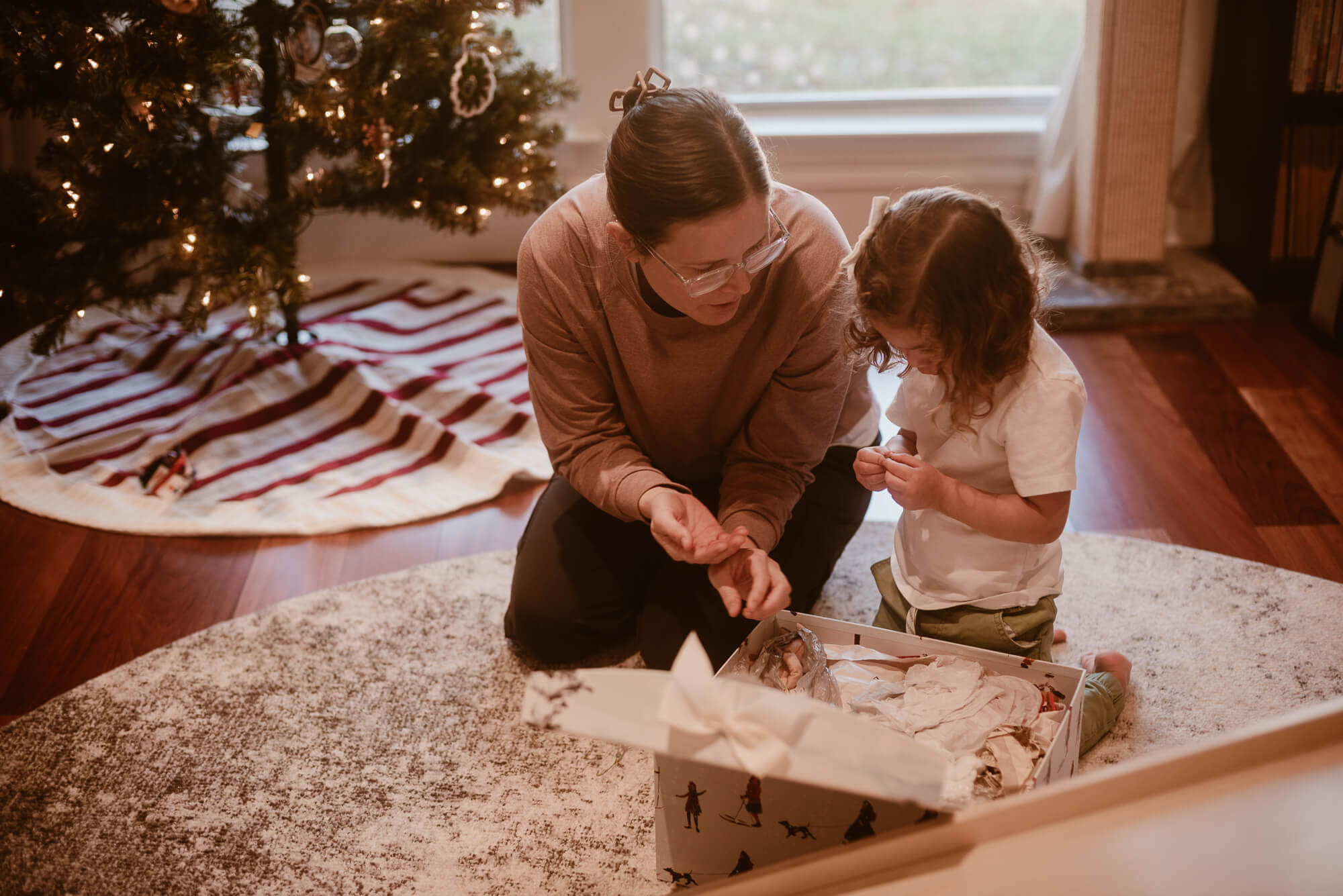 Toddler helping decorate the Christmas tree during an in-home family session