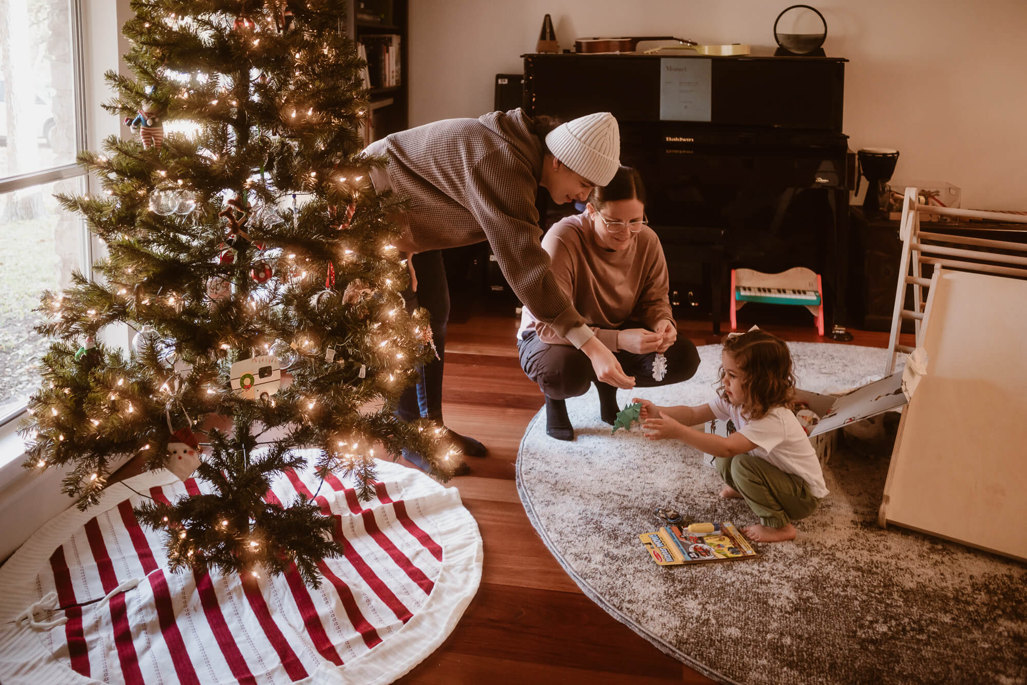 Toddler helping decorate the Christmas tree during an in-home family session