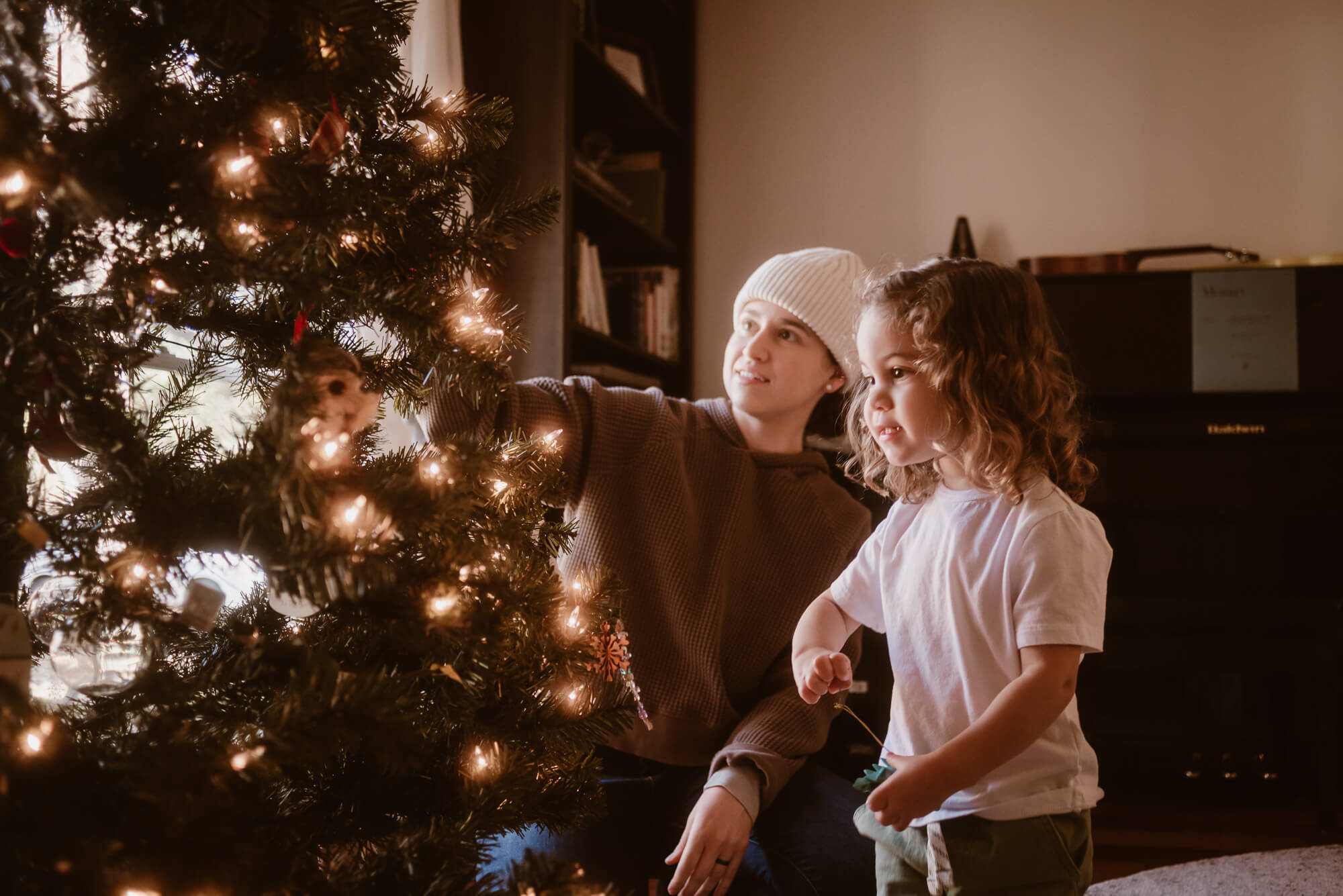Family decorating their Christmas tree together during an in-home session in Austin