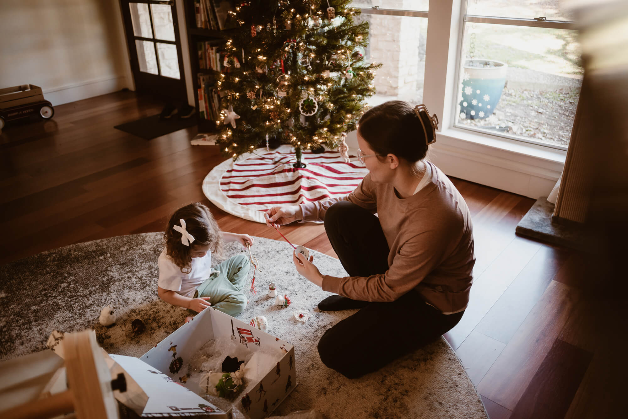 In-home Christmas family photography in Austin, family trimming the tree together