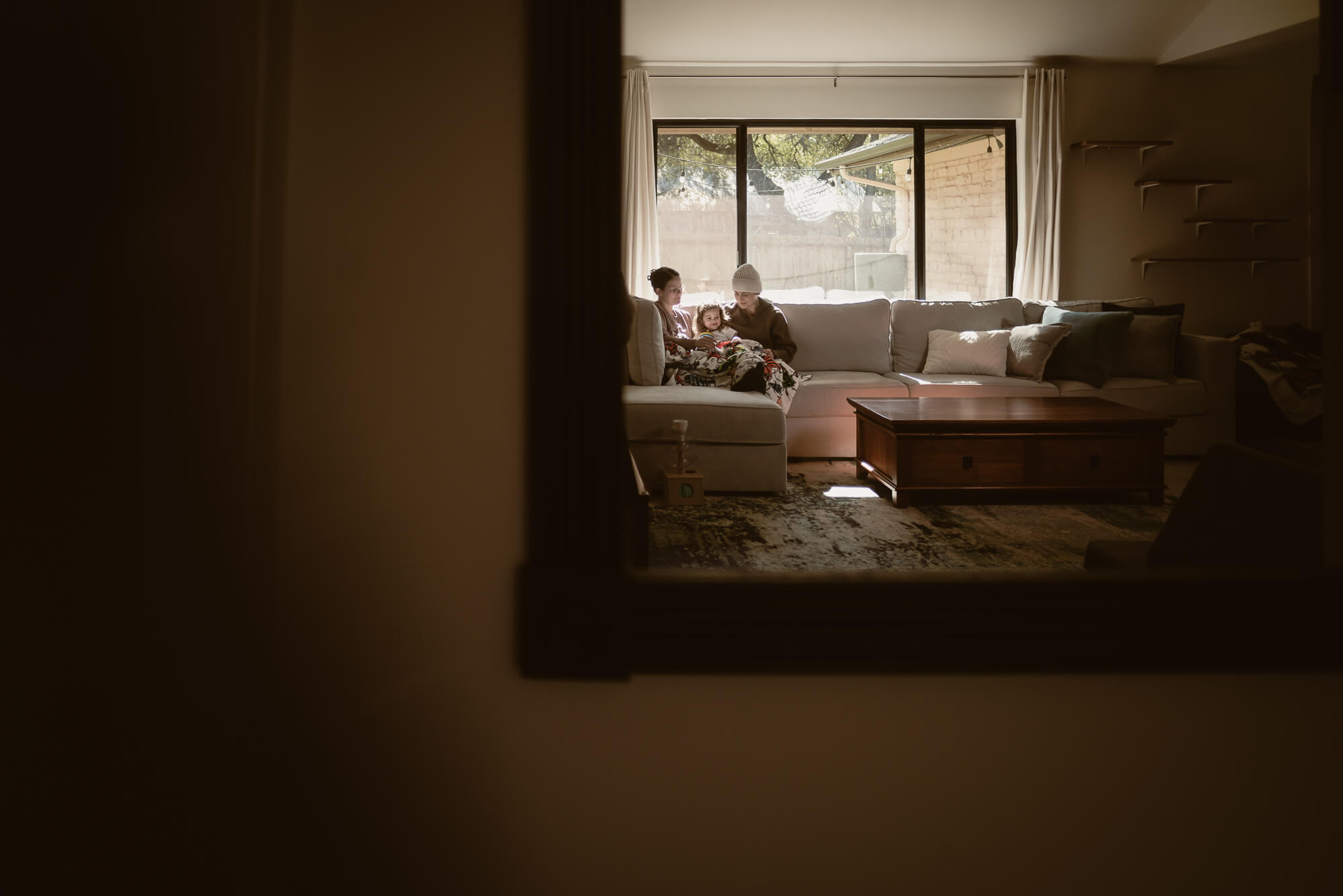 Family cuddled close together in their living room during an in-home holiday session