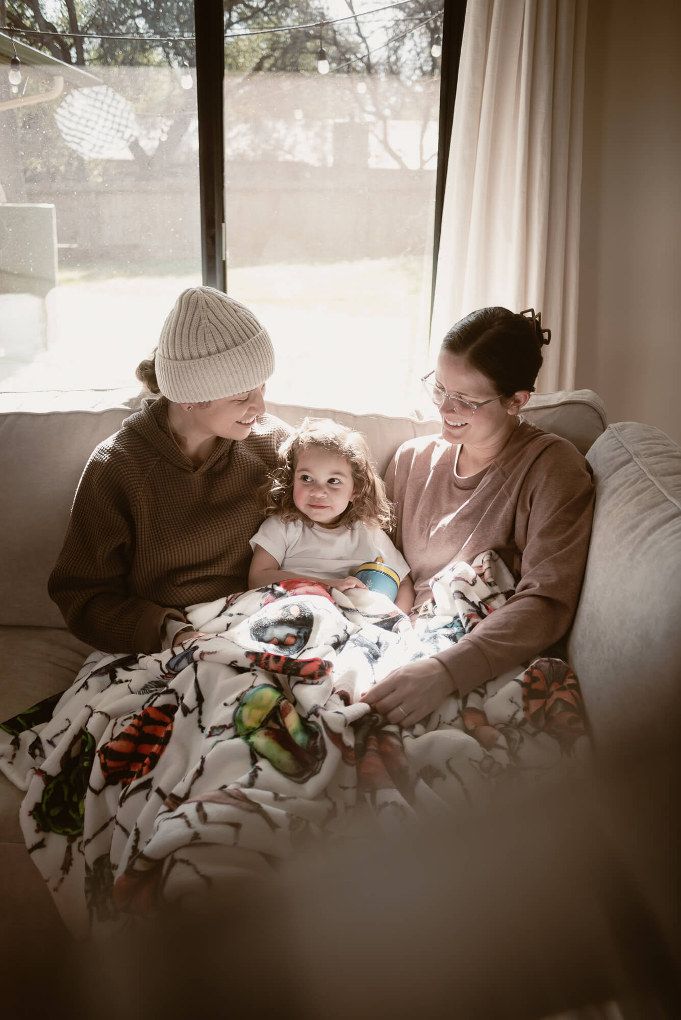 Family cuddled close together in their living room during an in-home holiday session