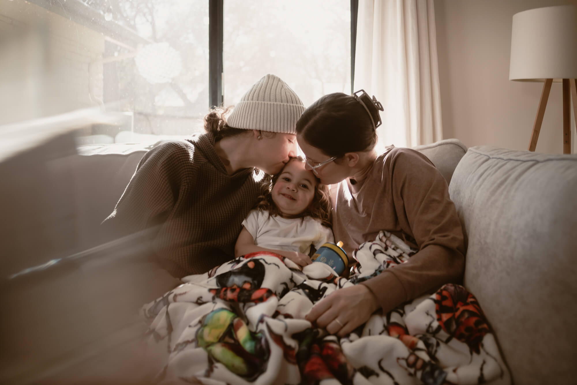 Family cuddled close together in their living room during an in-home holiday session