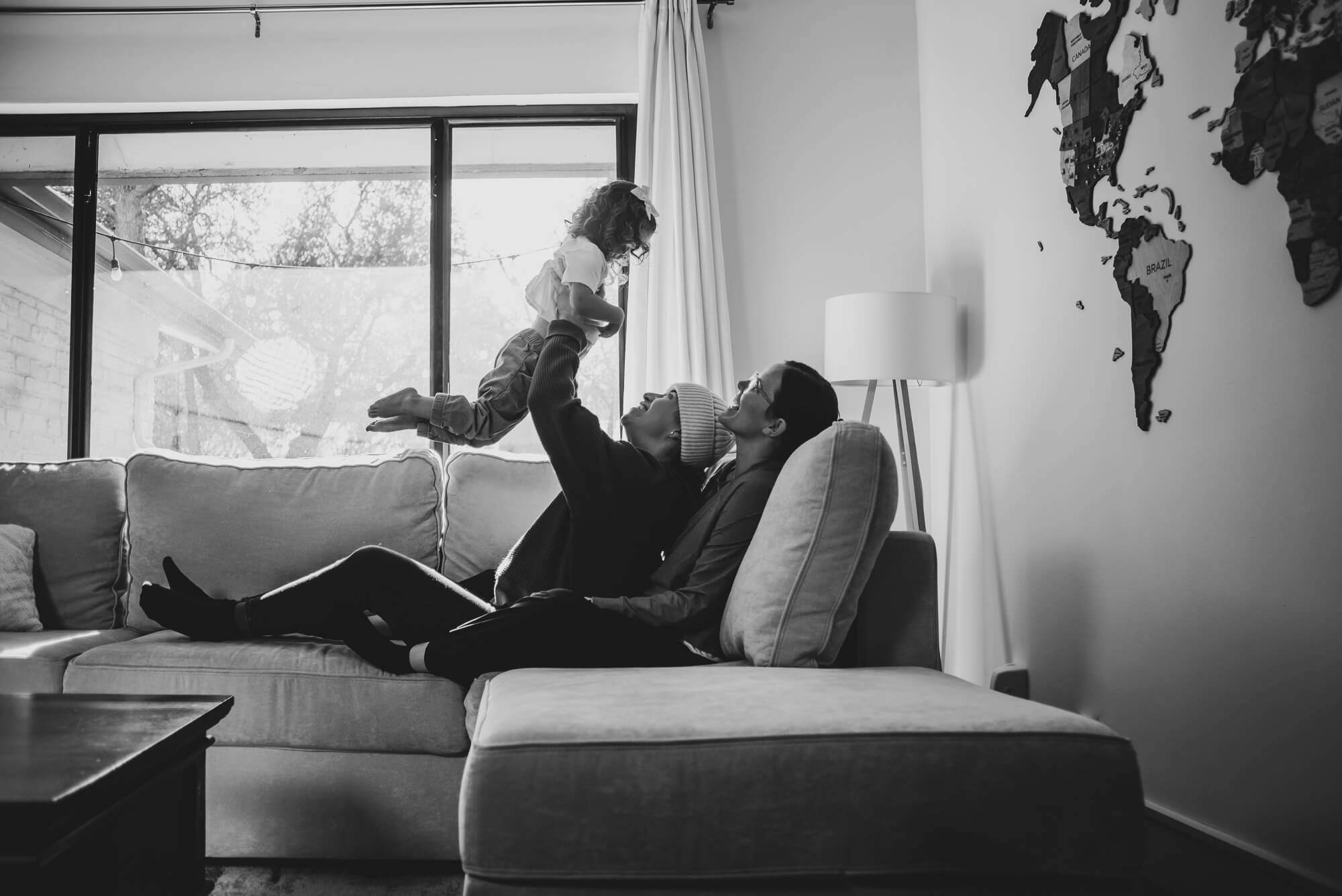 Family cuddled close together in their living room during an in-home holiday session