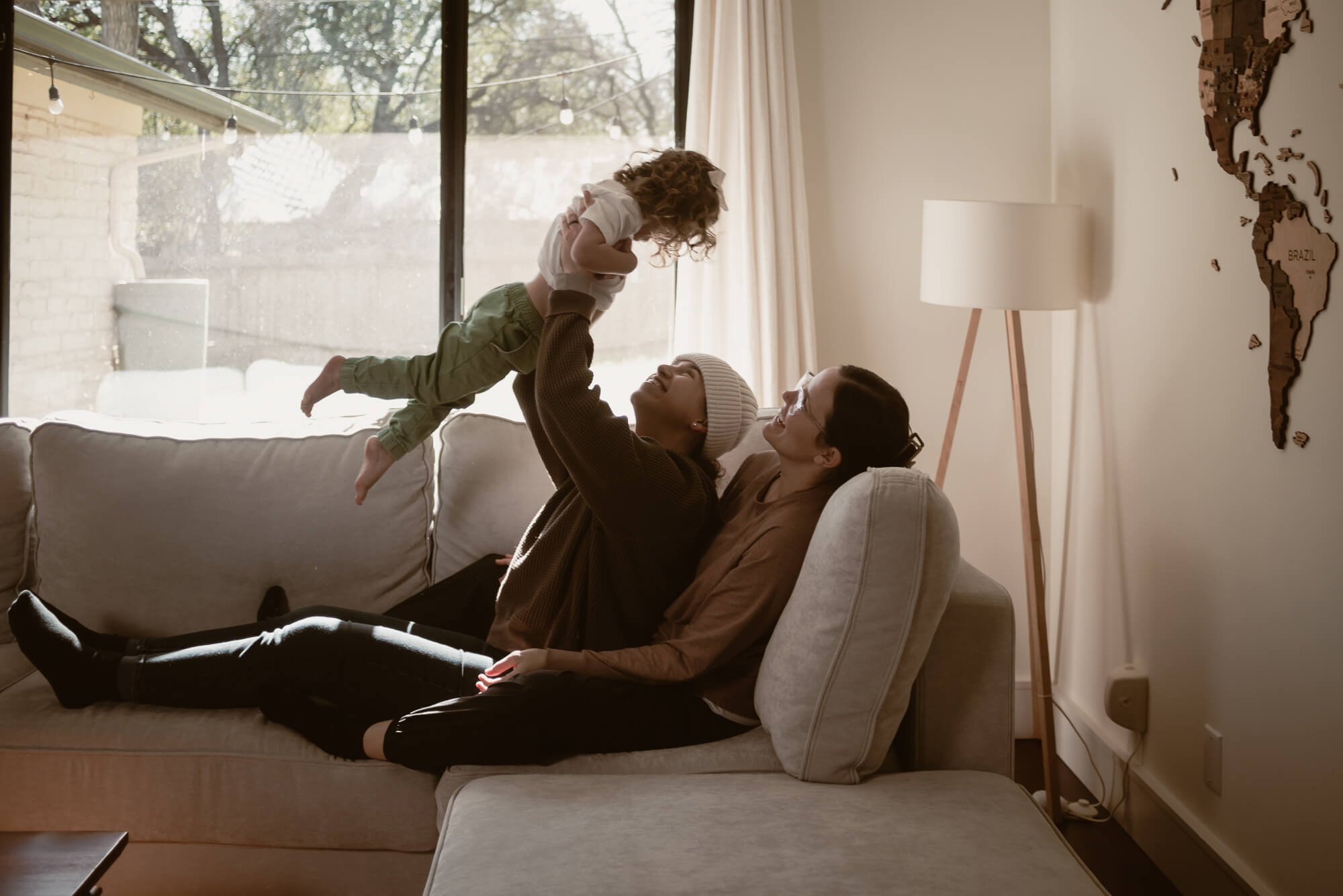 Family cuddled close together in their living room during an in-home holiday session