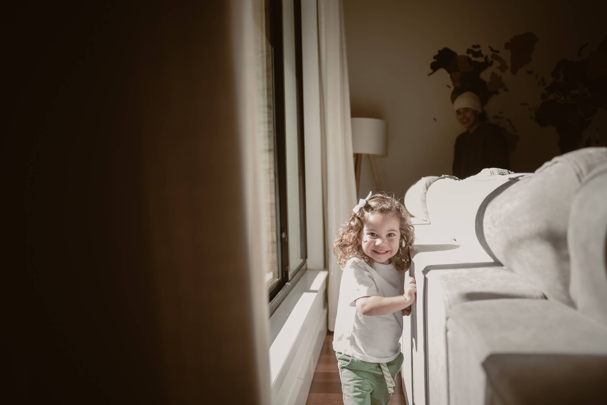 toddler playing chasing with her parents in the living room