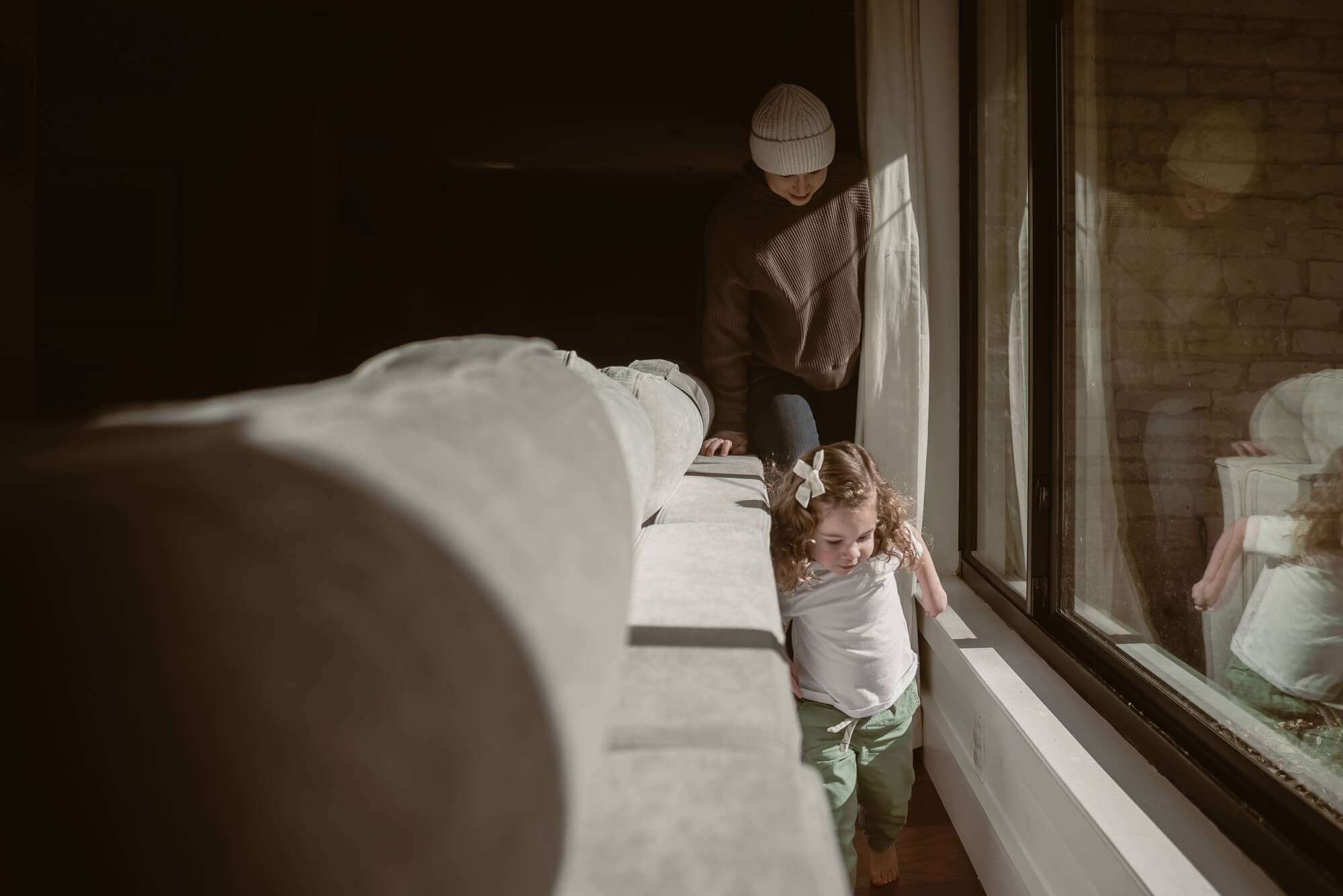 toddler playing chasing with her parents in the living room