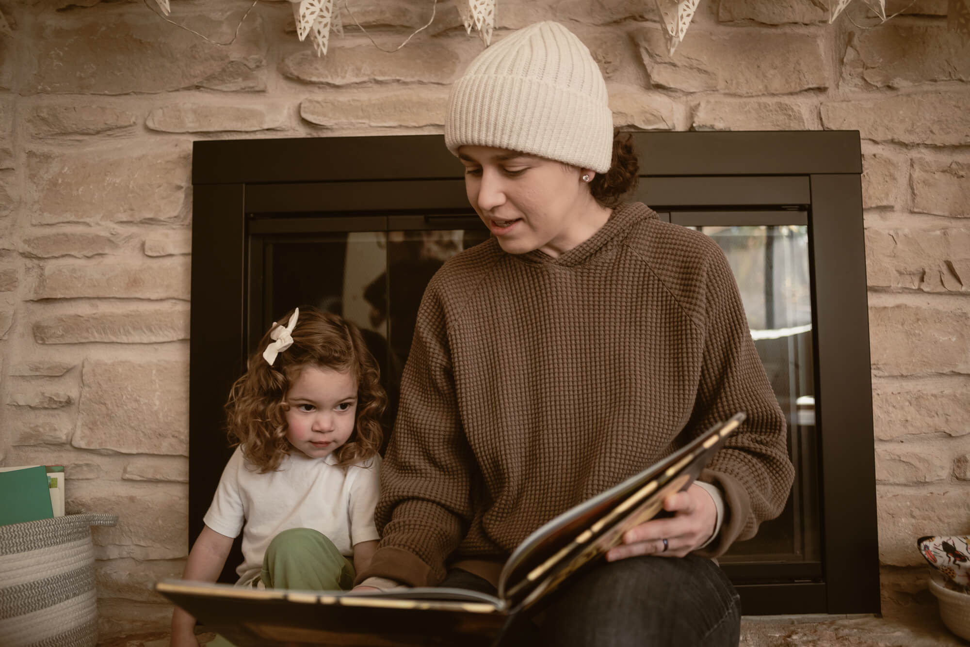 Family reading to their toddler in the living room during their indoor family photoshoot